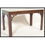 A mahogany coffee table with marble top raised on