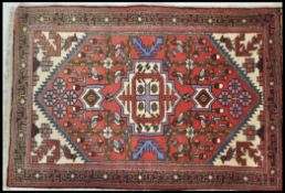 A 20th Century Persian carpet floor rug having a red ground with central tree of life panel and