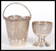 Two pieces of early 20th Century Middle Eastern silver to include an egg cup raised on stepped