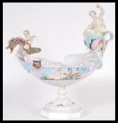 A continental ceramic figurine figural centerpiece bowl in the manner of Meissen / Dresden raised on