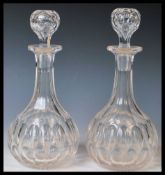 Two 20th Century cut lead glass decanters each faceted stoppers above faceted neck and body with cut