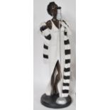 A collection of tall Art Deco style composite figurines to include an embracing couple, a jazz