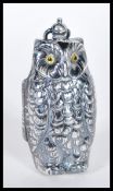 A silver plated sovereign vase with the form of an owl having yellow glass eyes with bale hoop to