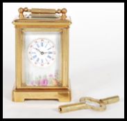 An 8 day brass cased miniature carriage clock having hand painted Limoges enamel porcelain