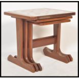 A retro 20th Century teak wood tile top nest of graduating tables, the graduating tables raised on L