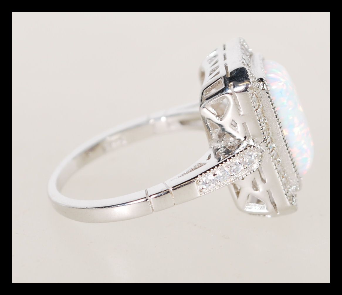 A sterling silver Art Deco style ring having a central opal panel and decorated with CZ stones. - Image 2 of 4
