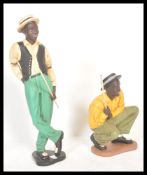 A pair of 20th century resin cast figurines of American black negro jazz singer / musicians. Each