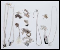 A selection of silver necklaces and pendants to include a selection of fine chains, a monogram M