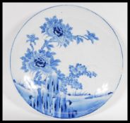 A 19th Century Chinese charger plate having a white ground with hand painted blue florals, and
