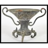 A 19th Century Chinese bronze twin handled pedestal oil burner, raised on tripod scroll feet with