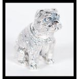 A sterling silver figurine in the form of a dog modelled in a seated position. Weighs 19 grams.