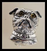 A sterling silver brooch / pendant in the form of a dog having yellow glass eyes. Weighs 13 grams.