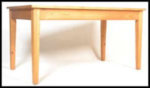 A 20th century antique style pine farmhouse dining table of rectangular form with thick plank top,