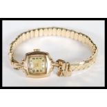 A 9ct gold ladies cocktail dress watch set to a rolled gold expanding bracelet. The watch with