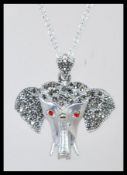 A sterling silver and marcasite set necklace pendant in the form of an elephant with red stone eyes.