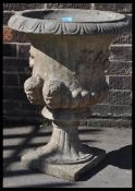 An early 20th Century reconstituted stone garden urn planter, well weathered fluted socle and