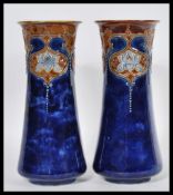 A pair of early 20th Century Royal Doulton tapering cylindrical stoneware vases decorated with Art