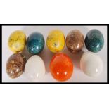 A collection of 20th Century geological marble eggs of different colours including green, yellow,