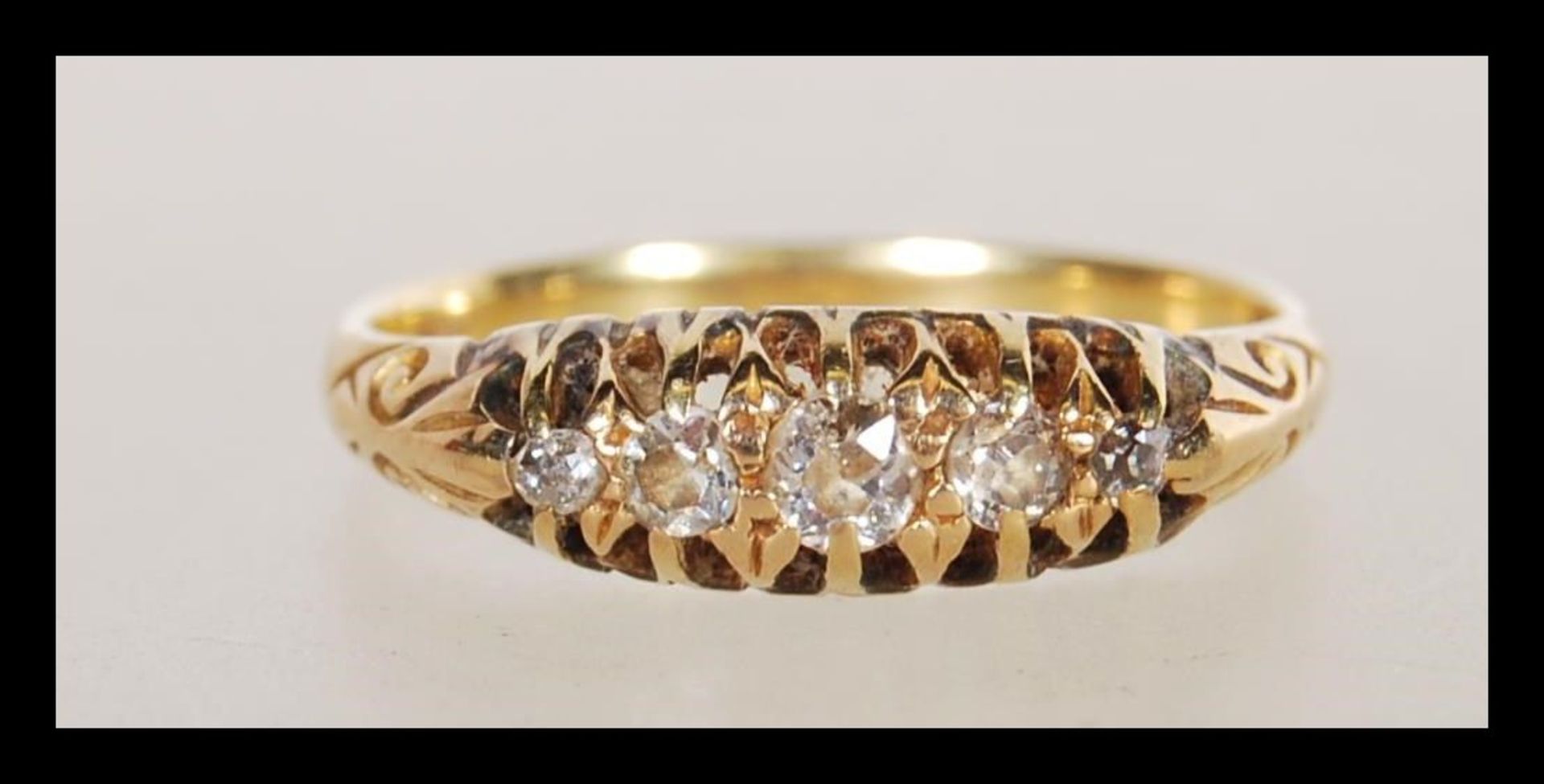 An 18ct gold five stone diamond ring having a flush group of graduating five brilliant cut diamonds.