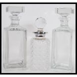 A group of three vintage 20th Century glass decanters to include a cut glass example with a pair