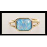 A hallmarked 9ct gold ring having a central octagonal bezel set opal cabochon doublet. Weighs 1.9