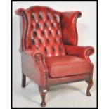 An antique style Chesterfield red oxblood leather armchair arm chair raised on cabriole legs with