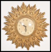 A vintage 20th Century Art Deco type sunburst starburst rising sun wall clock having a gilt