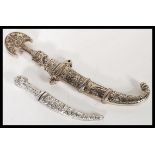 Two vintage 20th Century silver white metal daggers in sheaves comprising of a Jambiya dagger with