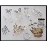 A collection of vintage brooches to include a brass scottie dog brooch, an enamelled butterfly