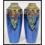 A Royal Doulton pair of stoneware vases on a mottled blue ground decorated with fruit, impressed