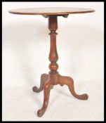 An early 19th Century Georgian mahogany folding tilt top wine occasional table raised on tripod
