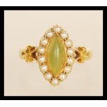 A stamped 18ct gold ladies dress ring set with a marquise cut green stone set with a halo of seed