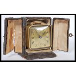 A vintage early 20th Century French Art Deco travel clock in fitted folding split door case. The