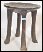 A 20th Century African hardwood stool carved from a single log of wood raised on four legs with