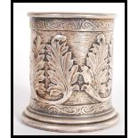 A hallmarked silver 925 brush pot of cylindrical form having scrolled decoration with relief leaf