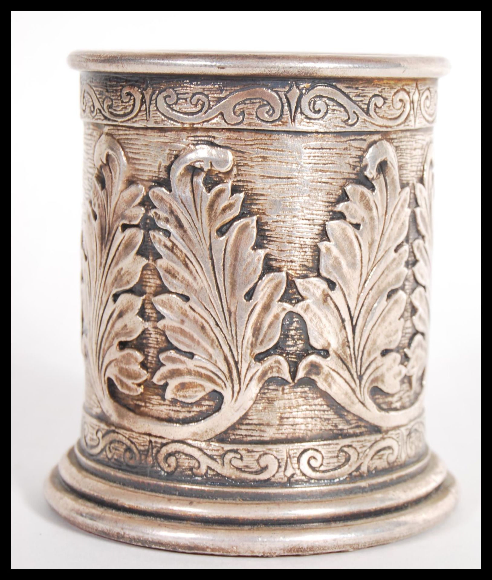 A hallmarked silver 925 brush pot of cylindrical form having scrolled decoration with relief leaf