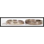 Two early 20th Century hallmarked silver bangle bracelets of circular form having engraved