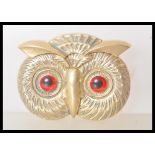 A brass vesta case in the form of an owl having red and black glass eyes, and match striker to the