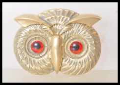 A brass vesta case in the form of an owl having red and black glass eyes, and match striker to the