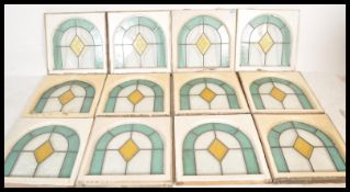 A set of 12 Art Deco leaded and stained glass windows (circa 1928) having domed tops with light blue