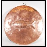 A vintage early 20th Century large circular copper fish mould / wall charger in the manner of