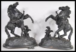 A pair of vintage 20th century spelter figurines of Marley horses and tamers raised on