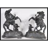 A pair of vintage 20th century spelter figurines of Marley horses and tamers raised on