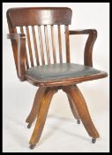 An early 20th century Industrial office swivel chair / desk armchair being raised on quadruped