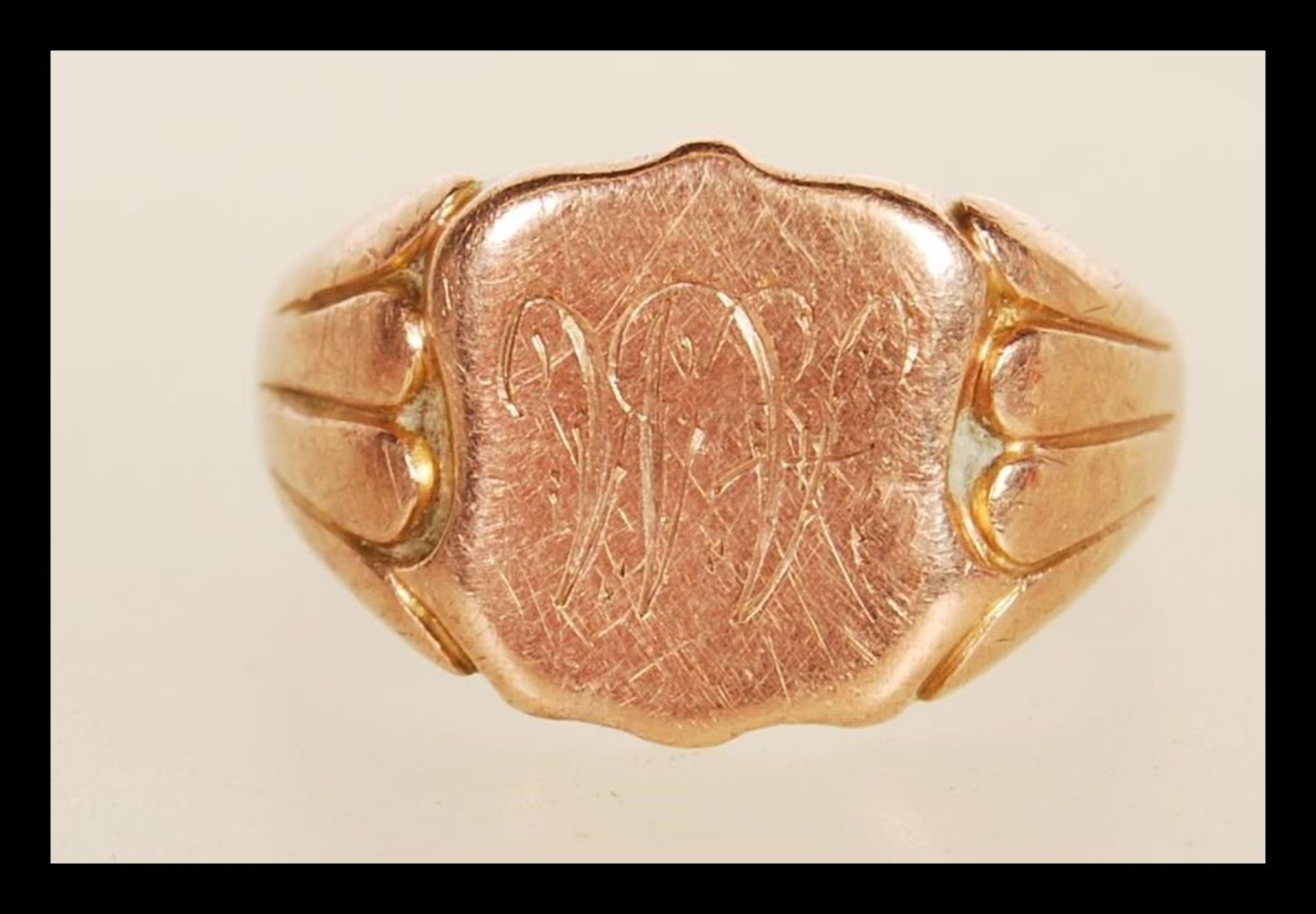 A hallmarked 9ct gold signet ring having a cartouche panel engraved with AM initials having reeded