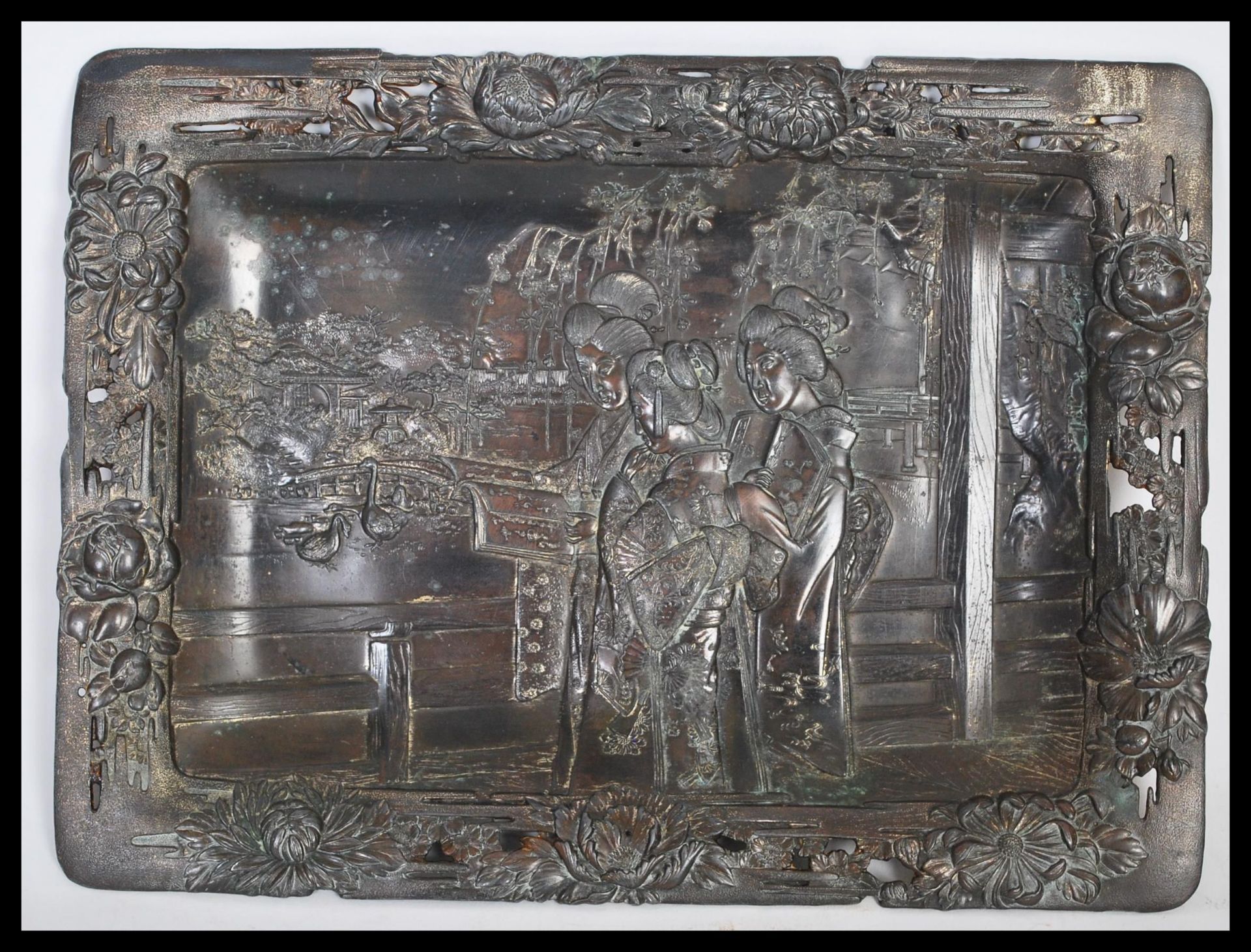 A Japanese bronzed tray, fret pierced border decorated with flowers having a central panel of