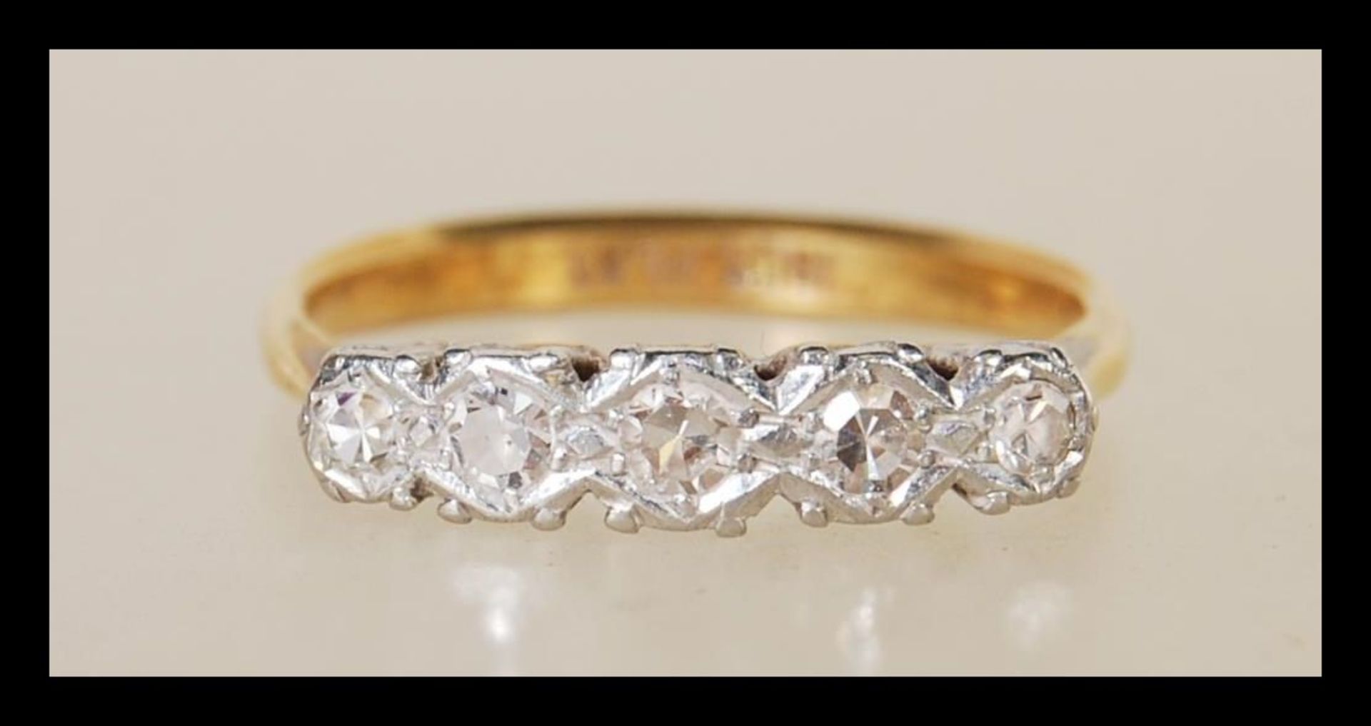 An 18ct gold and platinum five stone diamond ring having five claw set diamonds. Size K.5. Weighs