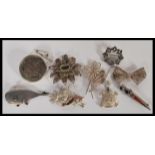 A group of eight silver brooches to include filigree flower and bow examples, marcasite leaf