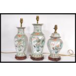 A collection of three 20th Century Chinese table lamps, decorated with panels depicting warriors