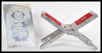 Two items of silver white metal Islamic wear to include a folding metamorphic Quran stand and a